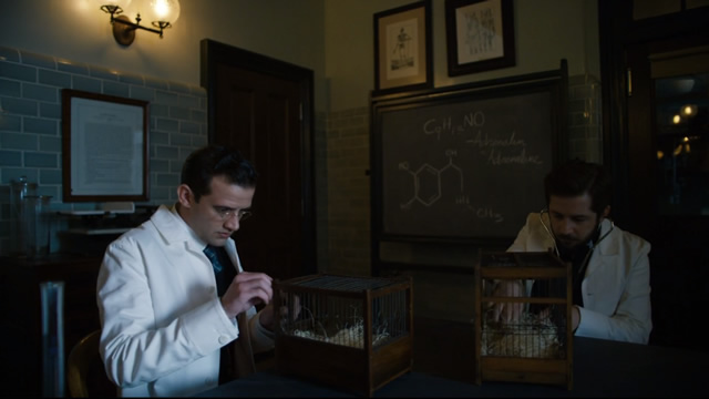 Dr. Bertrand Chickering, Jr. (right) runs into a little conflict by wanting to move too fast for his new team and is told, ”Dr. Zinberg is very specific about his protocols. Start on mice. Present our findings. Then on to rats, then guinea pigs, then cats, dogs, and pigs, and only then to humans.”
