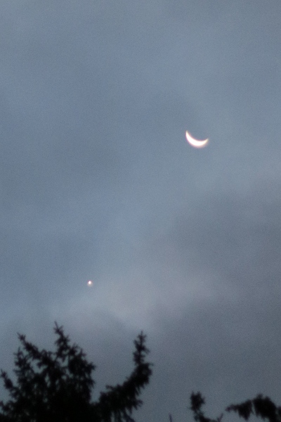 Venus and the crescent Moon through clouds.