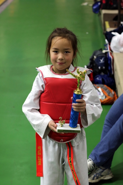 SteelyKid in sparring gear, with her second-place trophy.