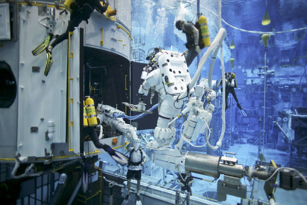 Image credit: NASA. This image shows Hubble servicing Mission 4 astronauts practice on a Hubble model underwater at the Neutral Buoyancy Lab in Houston under the watchful eyes of NASA engineers and safety divers.