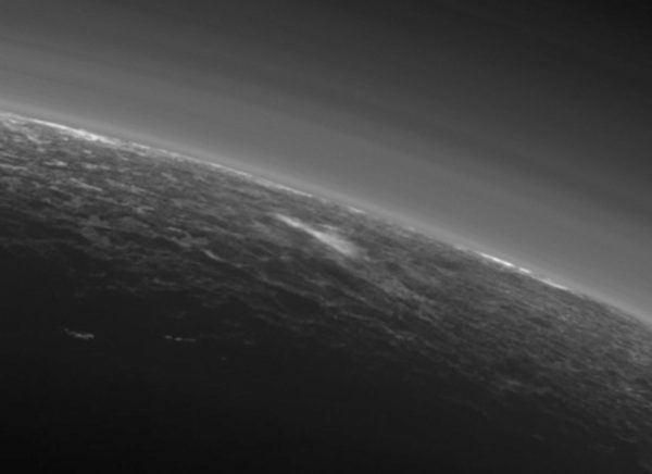 The dark (night) side of Pluto, showcasing layers of atmospheric haze and possible low-lying clouds (foreground) nearer to the surface. Image credit: NASA/JHUAPL/SwRI.