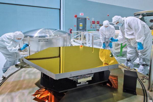 Technicians and scientists check out one of the Webb telescope's first two flight mirrors in the clean room at NASA's Goddard Space Flight Center. Image credit: NASA / Chris Gunn.