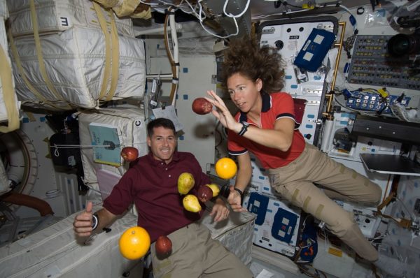Astronauts, and fruit, aboard the International Space Station. Note that gravity isn't turned off, but that everything -- including the spacecraft -- is uniformly accelerated, resulting in a zero-g experience. Public domain image.