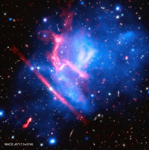 The combination of radio and X-ray data reveal background, lensed galaxies and signatures of active black holes within the colliding cluster. Image credit: X-ray: NASA/CXC/SAO/G.Ogrean et al.; Optical: NASA/STScI; Radio: NRAO/AUI/NSF.
