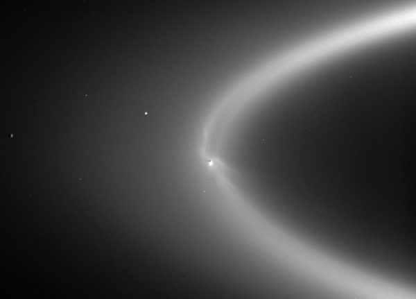 Saturn's E-Ring, as imaged here by Cassini, is created by it's frozen Moon, Enceladus, ejecting icy material over time. Enceladus is the bright spot at the image's center. Image credit: NASA/JPL/Space Science Institute.