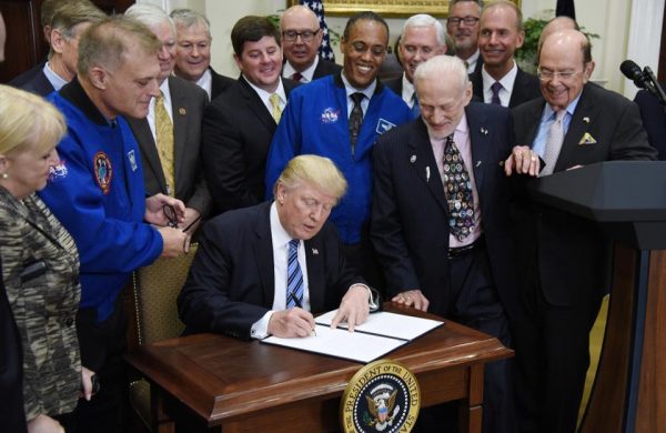 U.S President Donald Trump signs an Executive Order to reestablish the National Space Council as Buzz Aldrin looks on. Image credit: Olivier Douliery-Pool/Getty Images.